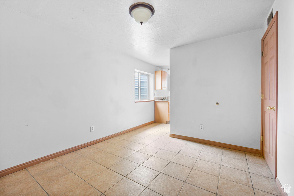 Empty room featuring light tile patterned floors