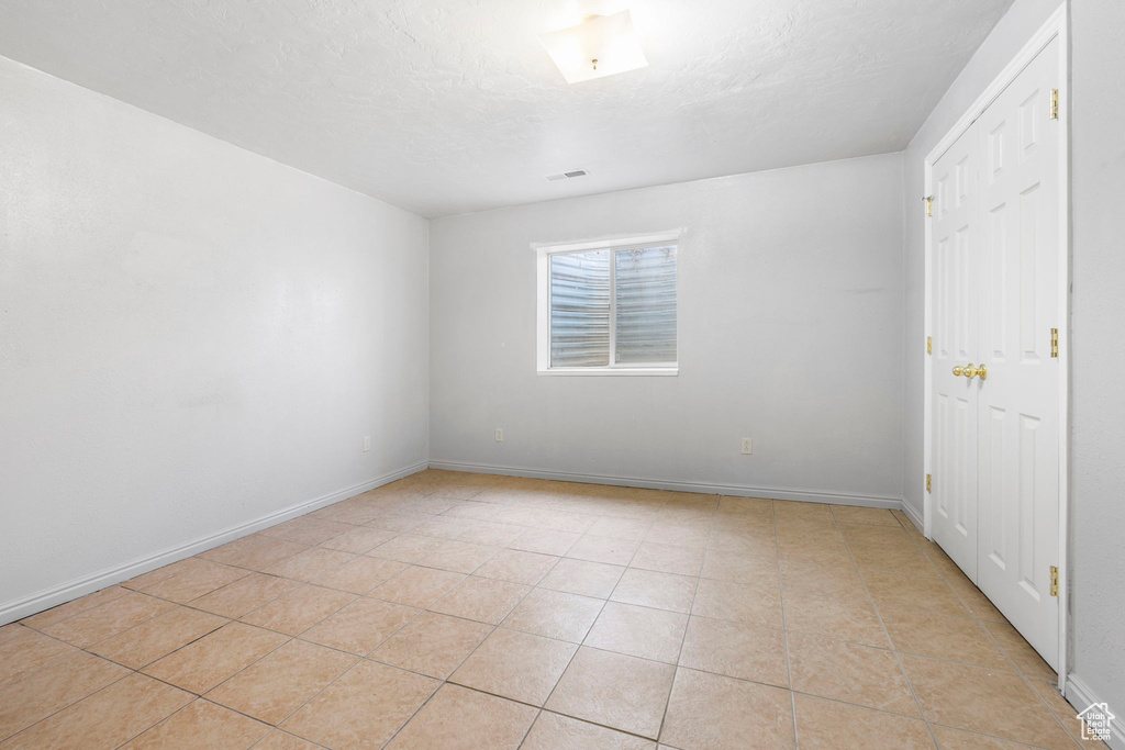 Tiled spare room with a textured ceiling