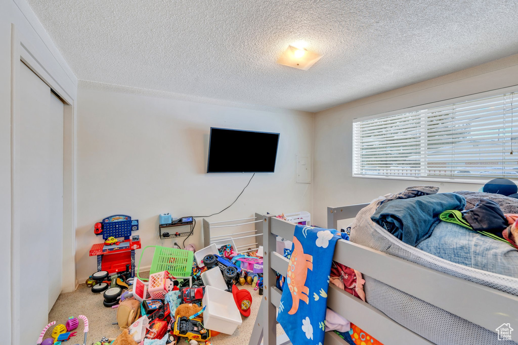 Playroom with a textured ceiling and carpet flooring