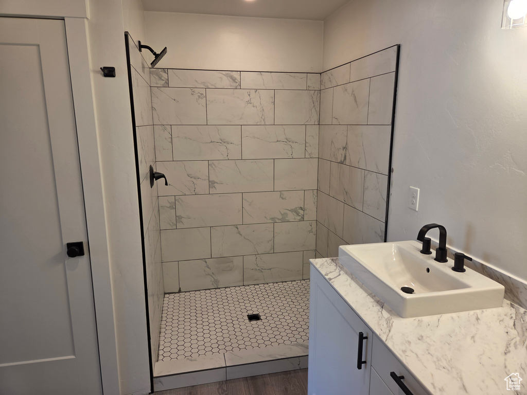 Bathroom featuring tiled shower and vanity