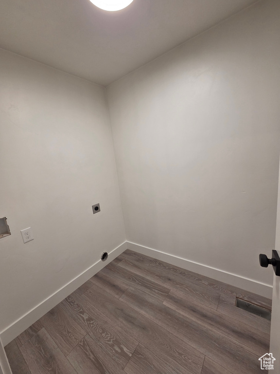 Laundry area featuring electric dryer hookup, dark wood-type flooring, and baseboards