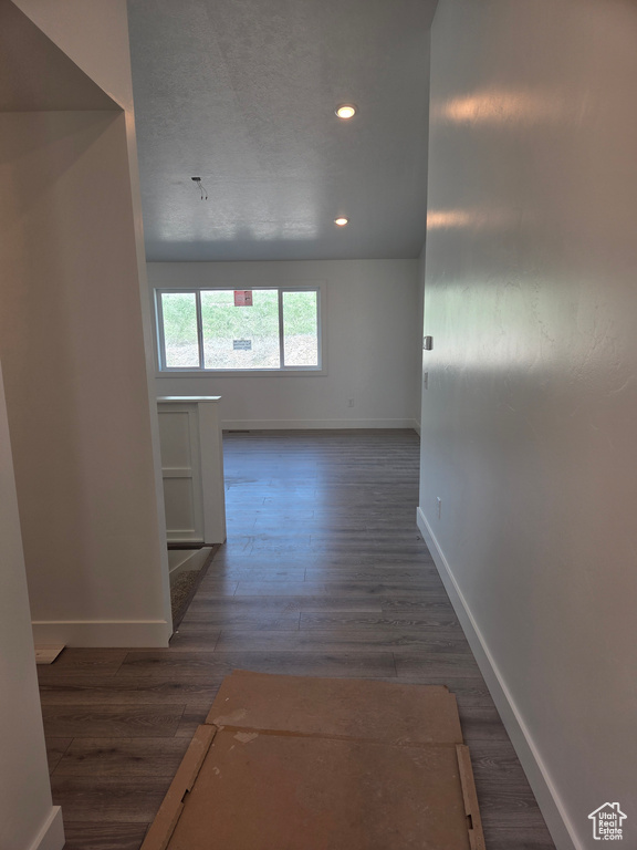 Corridor featuring baseboards, wood finished floors, and recessed lighting