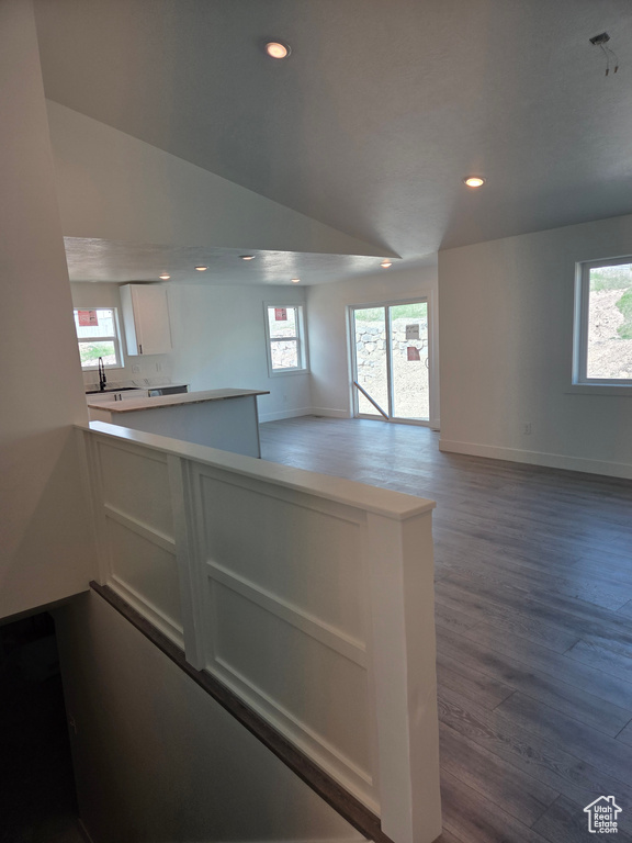 Kitchen with white cabinetry, wood finished floors, recessed lighting, baseboards, and open floor plan