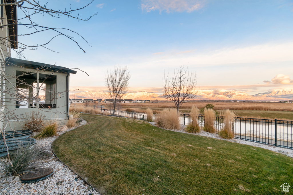 Yard at dusk with a rural view and a water and mountain view