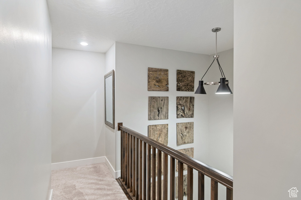 Hallway featuring light colored carpet