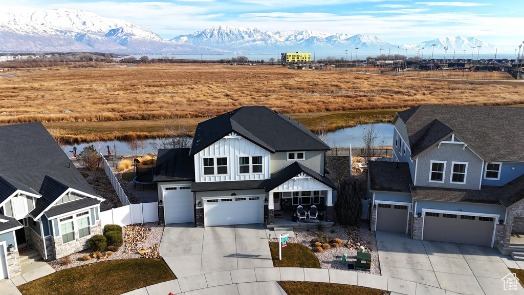 View of front of home featuring a water and mountain view and a garage