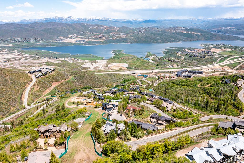 Aerial view of property's location featuring a water and mountain view and nearby suburban area