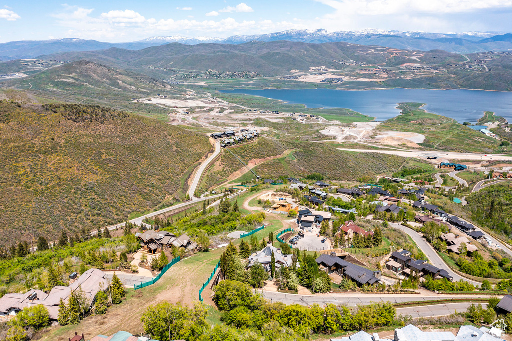 Aerial view of property and surrounding area featuring a water and mountain view and nearby suburban area