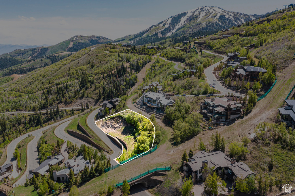Aerial view of property and surrounding area featuring a mountain backdrop and property parcel outlined