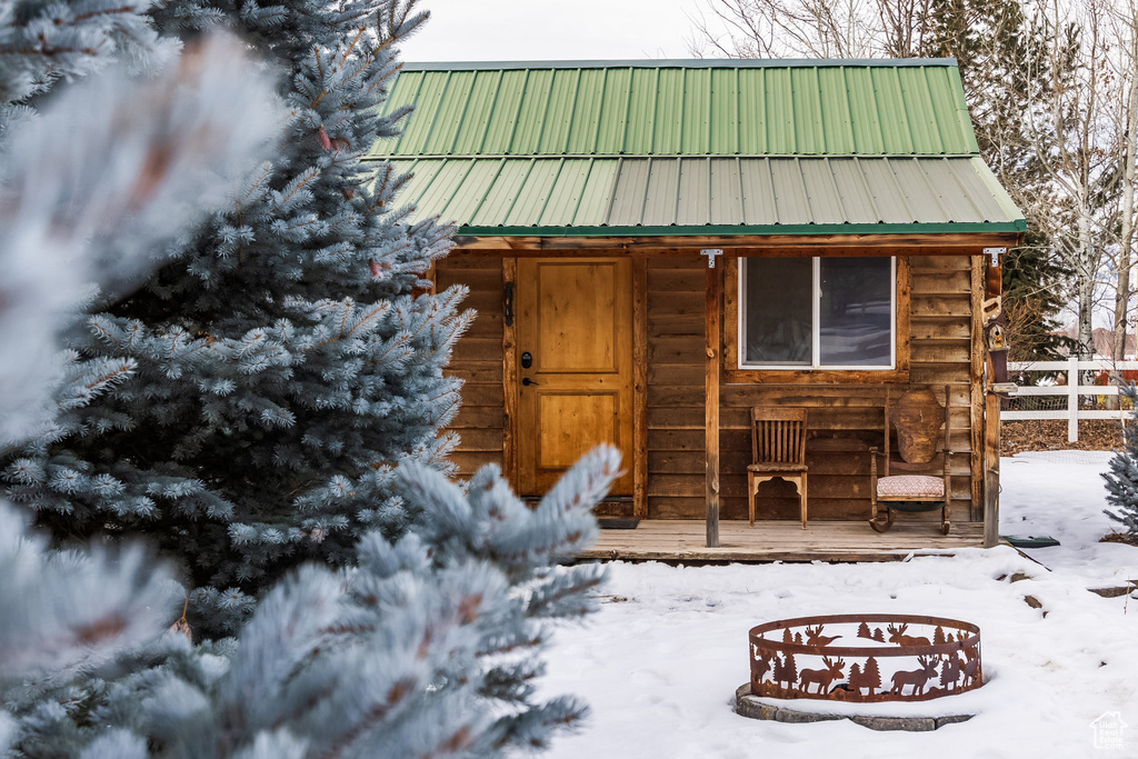 Snow covered structure with an outdoor structure and fence