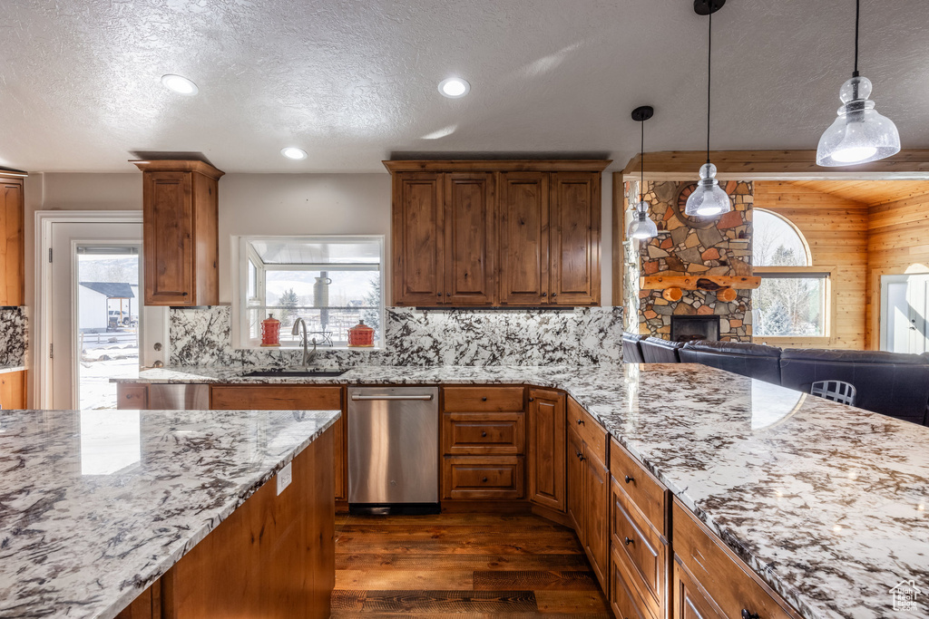 Kitchen with dark wood-style floors, a sink, tasteful backsplash, light stone counters, and a textured ceiling