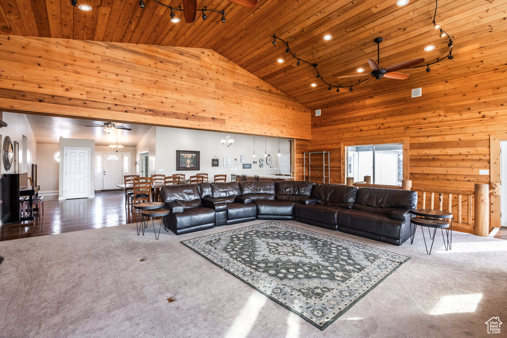 Carpeted living area featuring wooden ceiling, a ceiling fan, high vaulted ceiling, wood walls, and recessed lighting