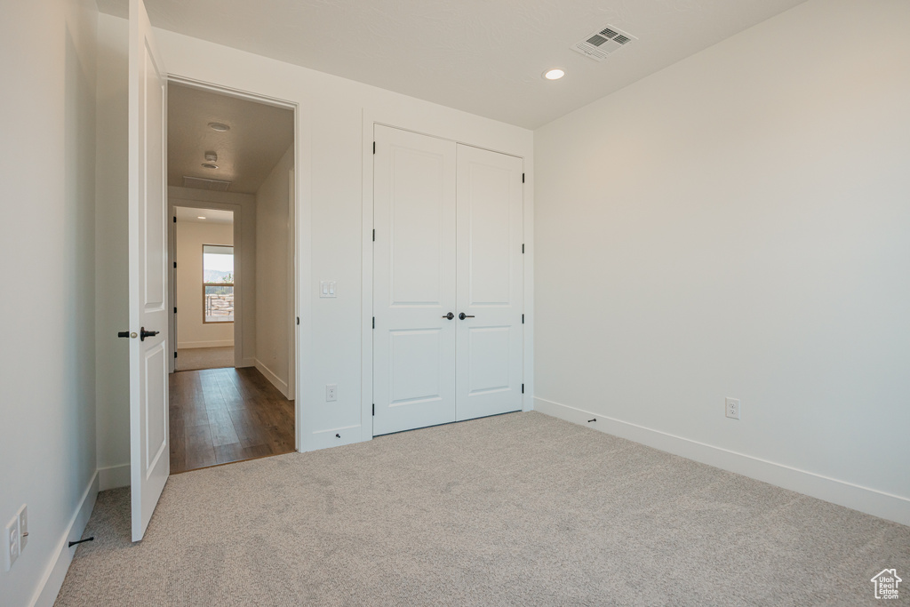 Unfurnished bedroom with carpet, a closet, and recessed lighting