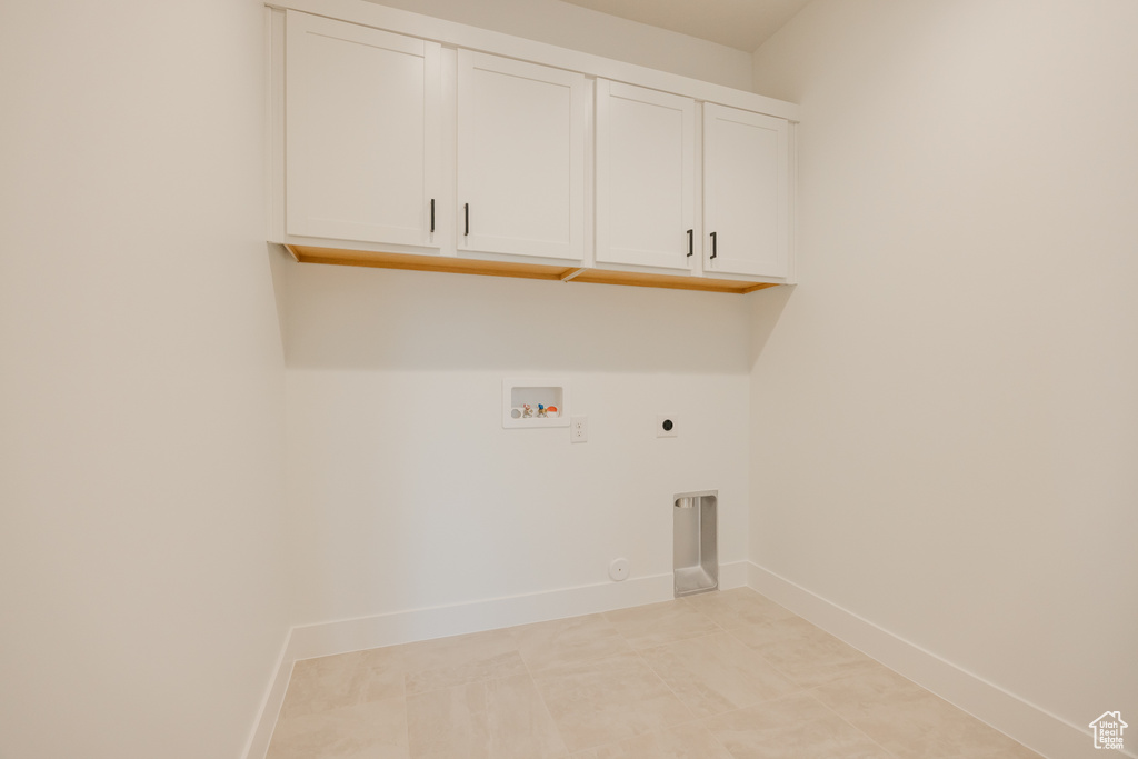 Washroom with hookup for an electric dryer, cabinet space, washer hookup, and gas dryer hookup