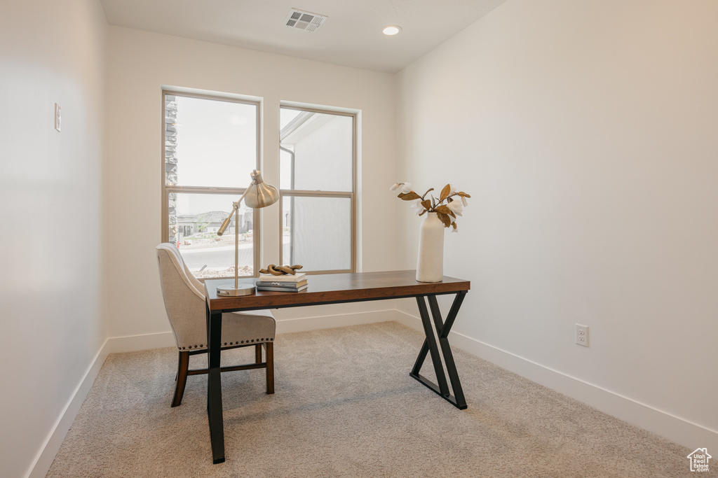 Carpeted home office featuring baseboards