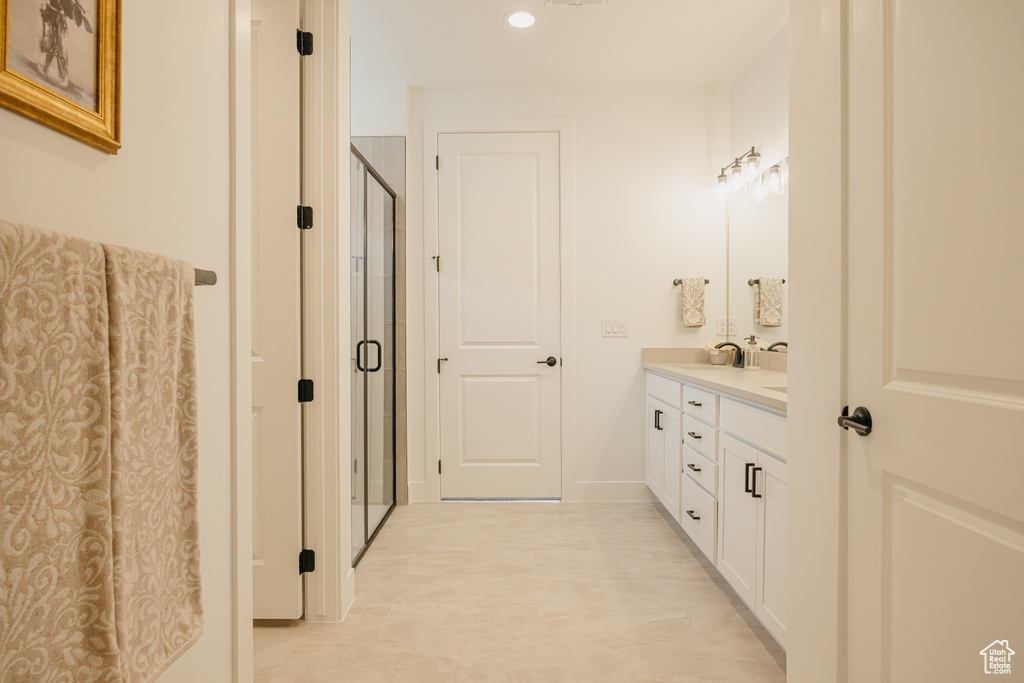 Bathroom featuring double vanity, a shower stall, recessed lighting, and tile patterned floors