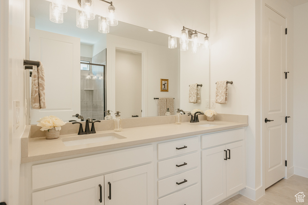 Full bathroom featuring double vanity and a stall shower