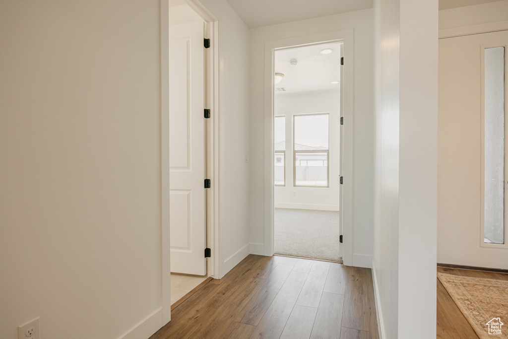 Hall with light wood-style flooring and baseboards