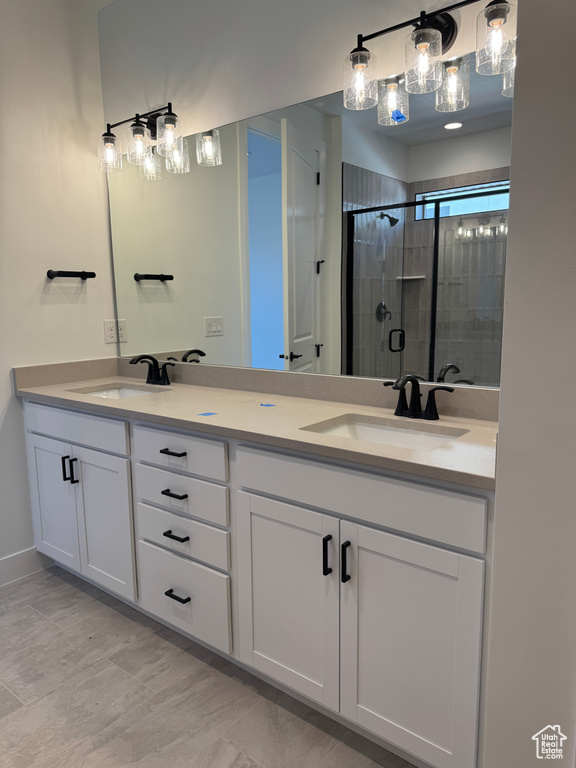Full bathroom featuring double vanity and a shower stall
