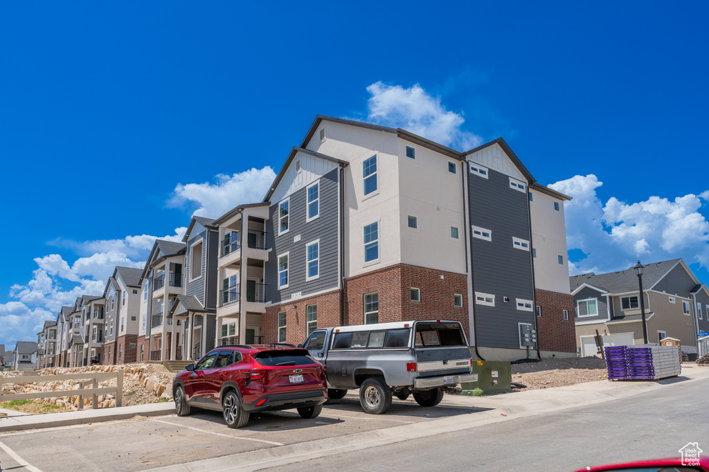 View of property with a residential view and uncovered parking