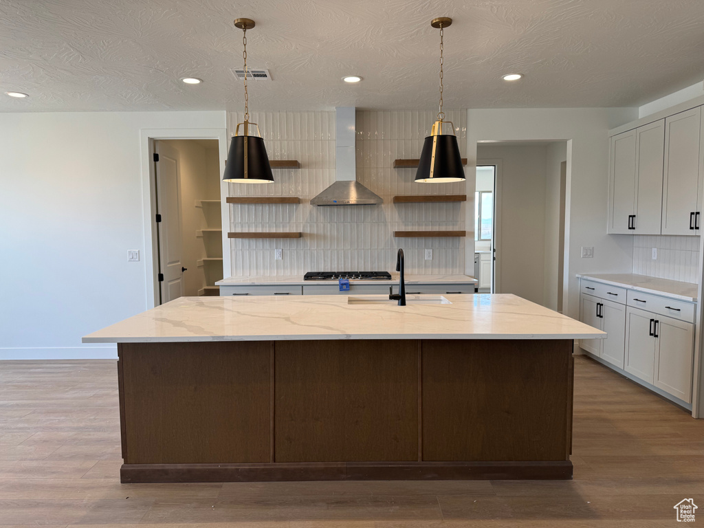 Kitchen with open shelves, wall chimney exhaust hood, decorative backsplash, recessed lighting, and a textured ceiling