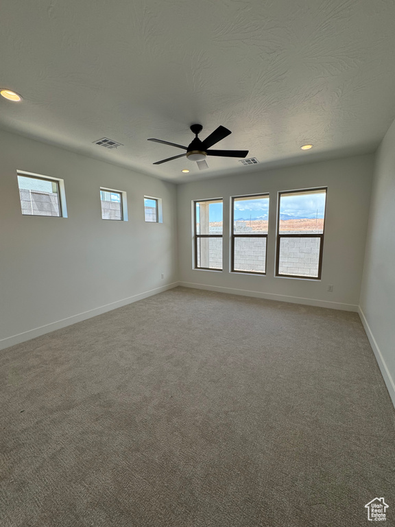 Empty room featuring light carpet, baseboards, recessed lighting, ceiling fan, and a textured ceiling