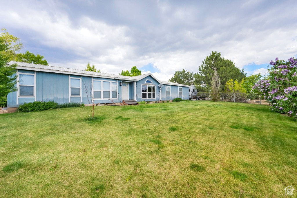 Back of property featuring a lawn and board and batten siding