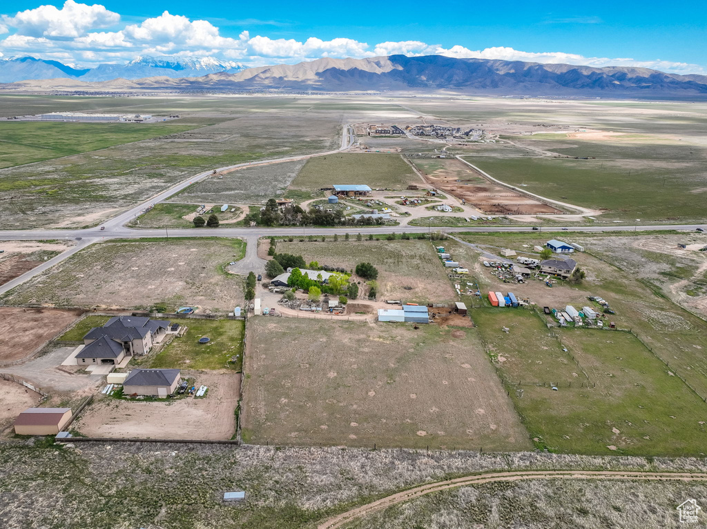 Aerial view of property and surrounding area featuring a mountain backdrop