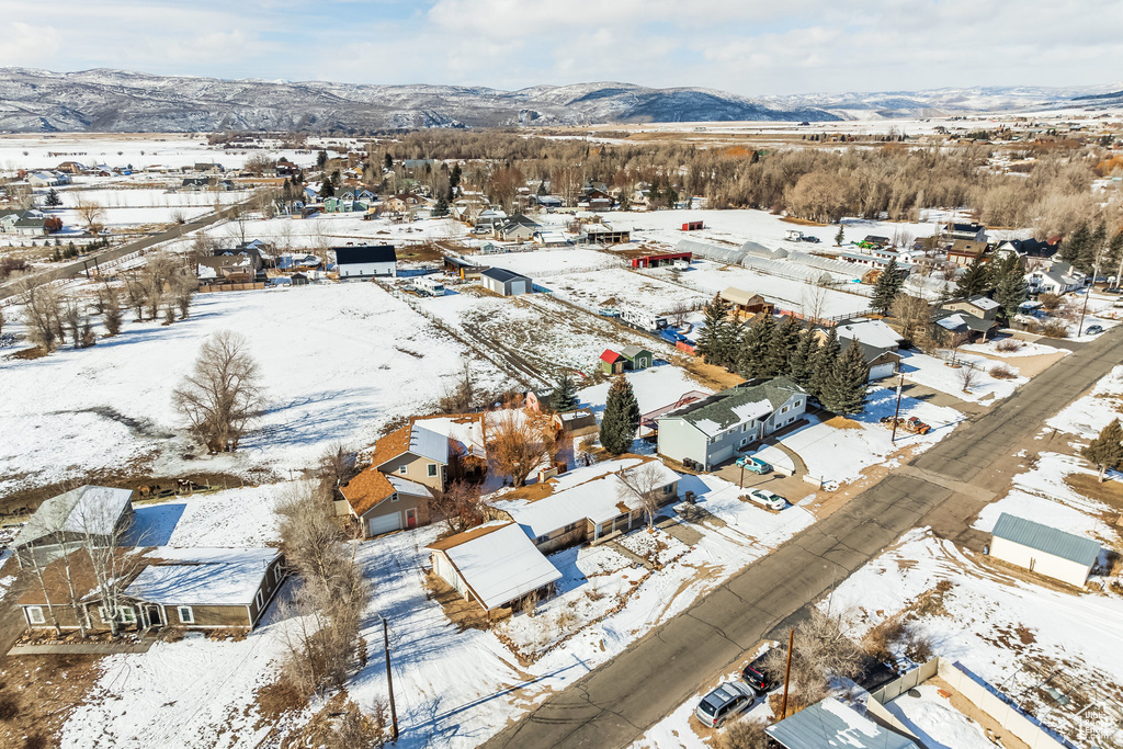 Snowy aerial view with a mountain view and a residential view