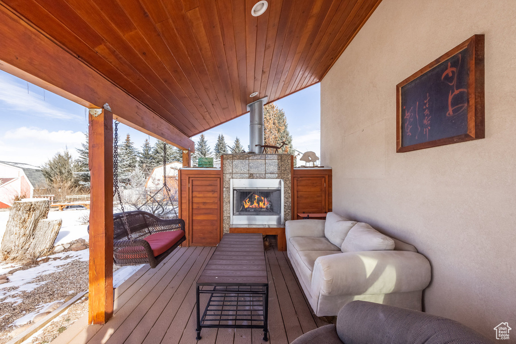 Snow covered deck with an outdoor living space with a fireplace