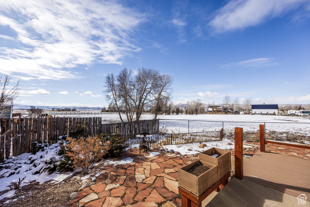 Snow covered patio with a deck