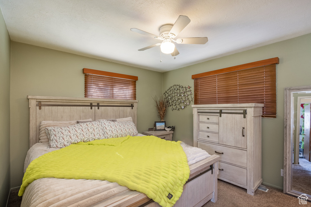 Carpeted bedroom featuring ceiling fan