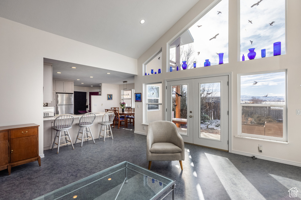 Living room with a high ceiling, baseboards, french doors, and recessed lighting