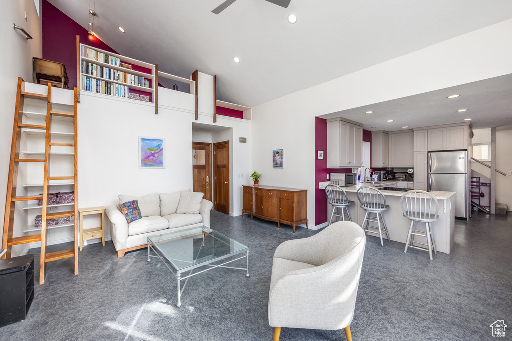 Living area with a ceiling fan, recessed lighting, and high vaulted ceiling