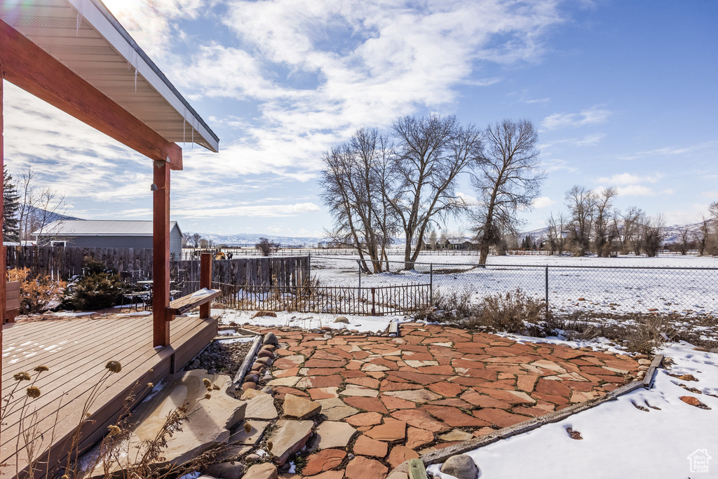 Yard covered in snow with a fenced backyard and a wooden deck