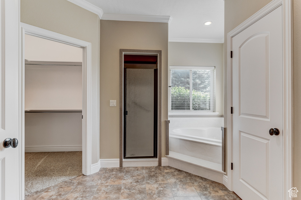 Full bath with ornamental molding, a garden tub, a stall shower, a walk in closet, and recessed lighting