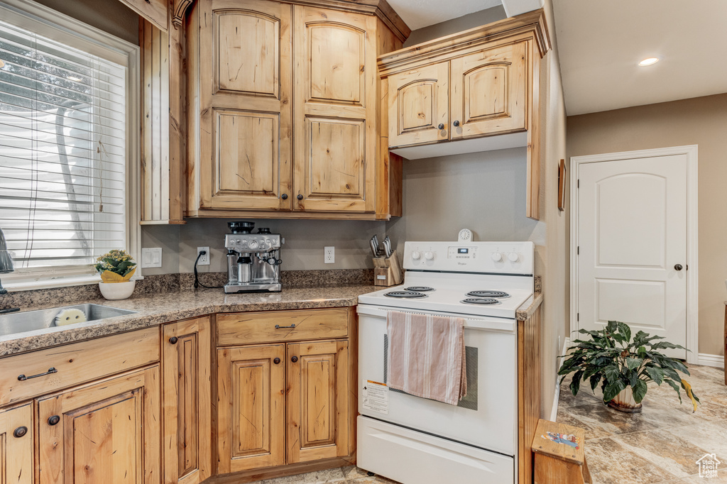 Kitchen featuring white electric range, plenty of natural light, light brown cabinetry, and recessed lighting