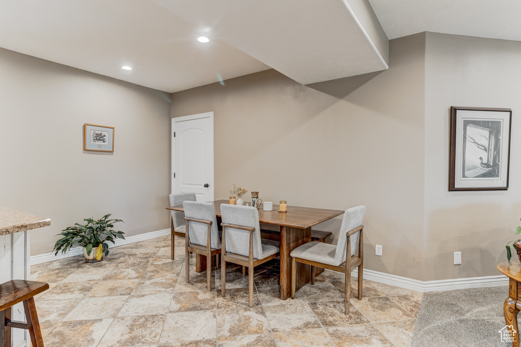 Dining space featuring recessed lighting and light stone finish floors