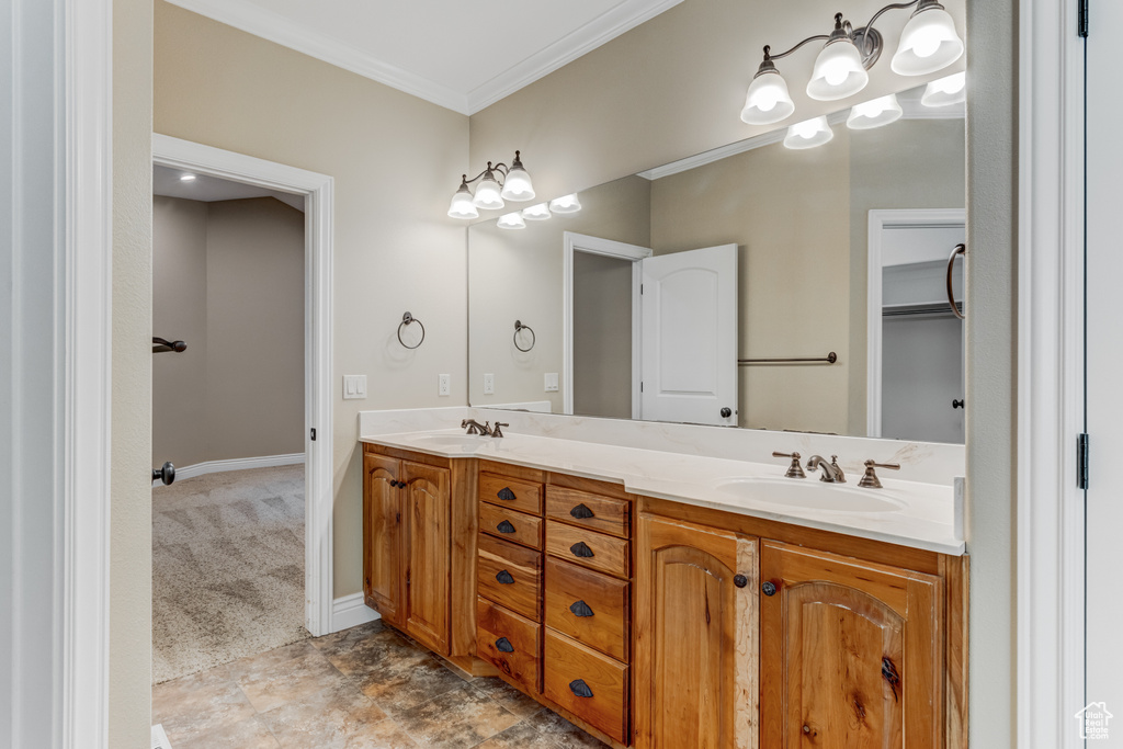Bathroom featuring double vanity and ornamental molding