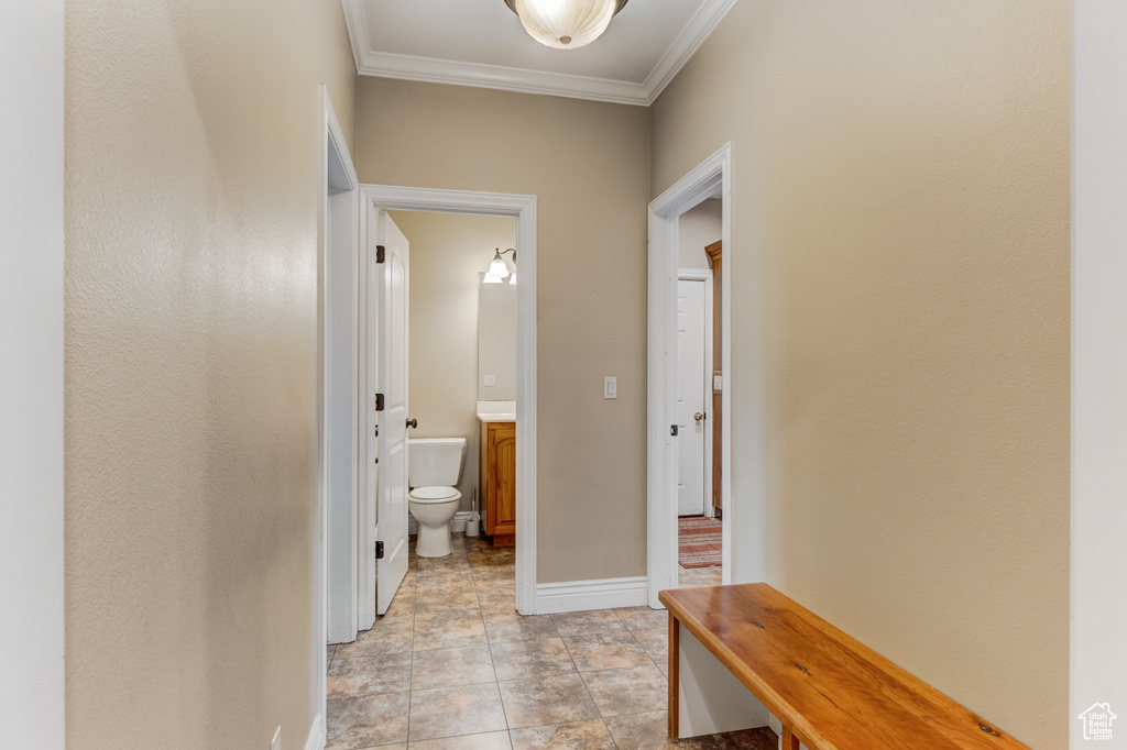 Corridor with ornamental molding and baseboards