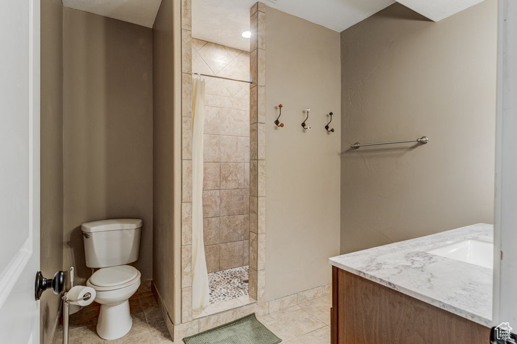 Full bath with a tile shower and vanity