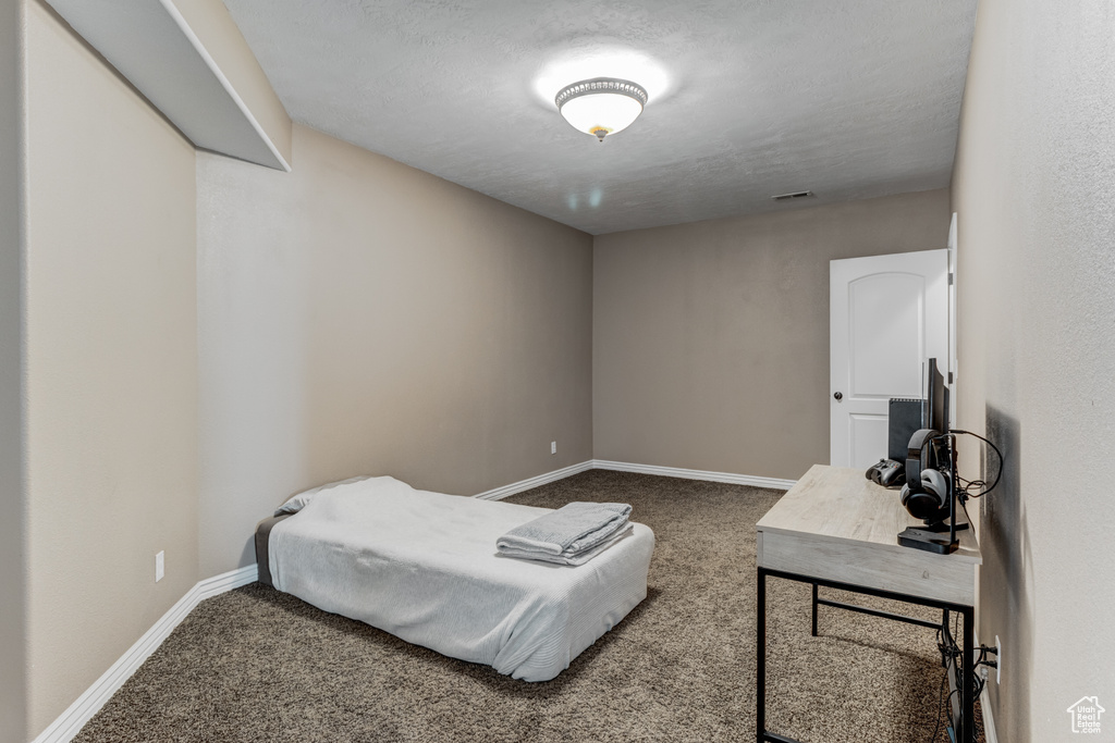 Bedroom with carpet floors and a textured ceiling