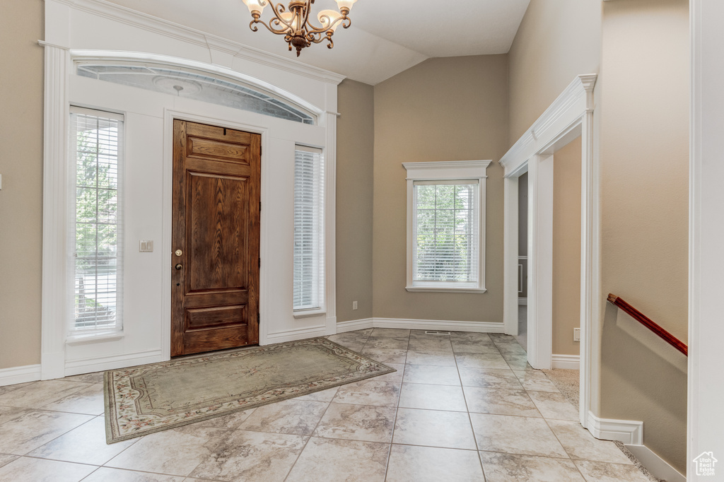 Entryway with lofted ceiling and a chandelier