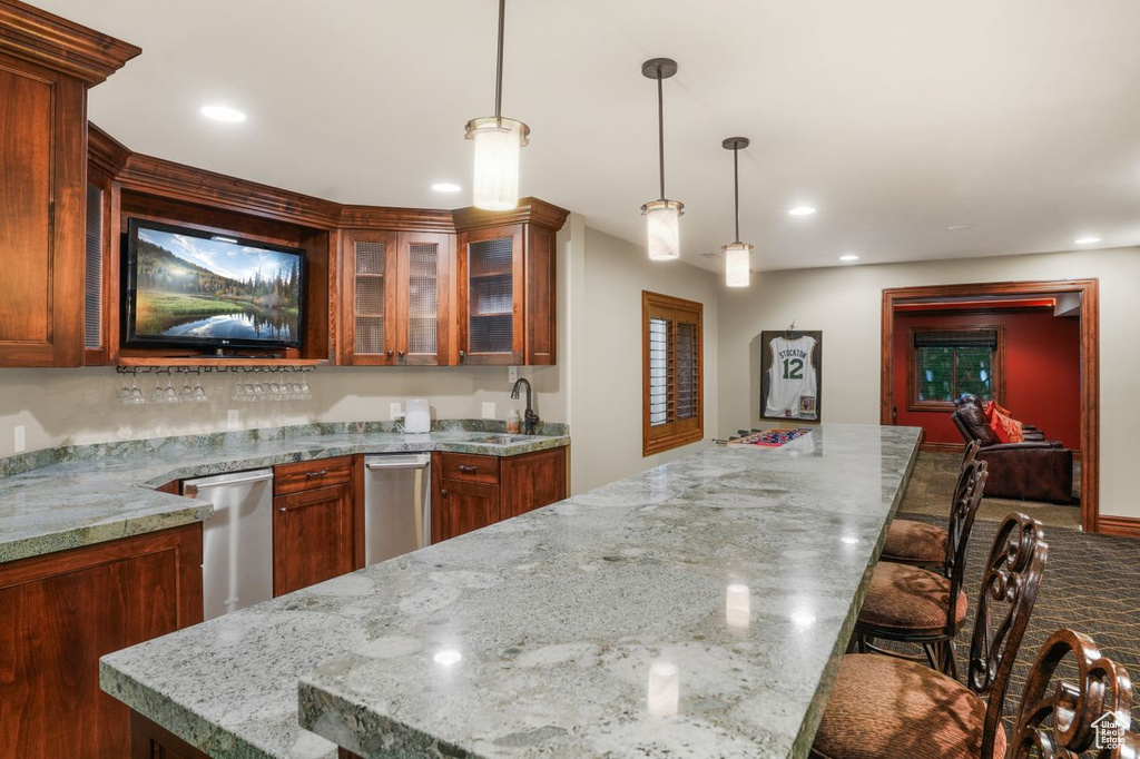 Kitchen featuring a kitchen breakfast bar, sink, hanging light fixtures, and a center island