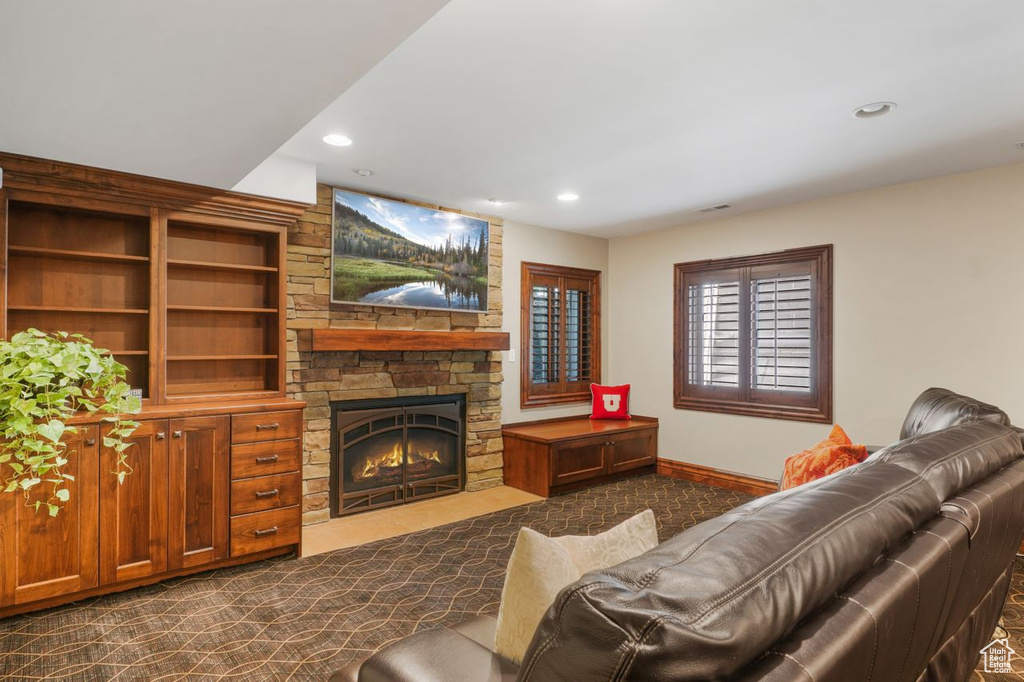Carpeted living room featuring a stone fireplace