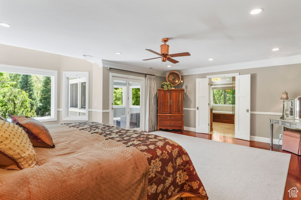 Bedroom featuring ensuite bathroom, hardwood / wood-style flooring, ceiling fan, and ornamental molding