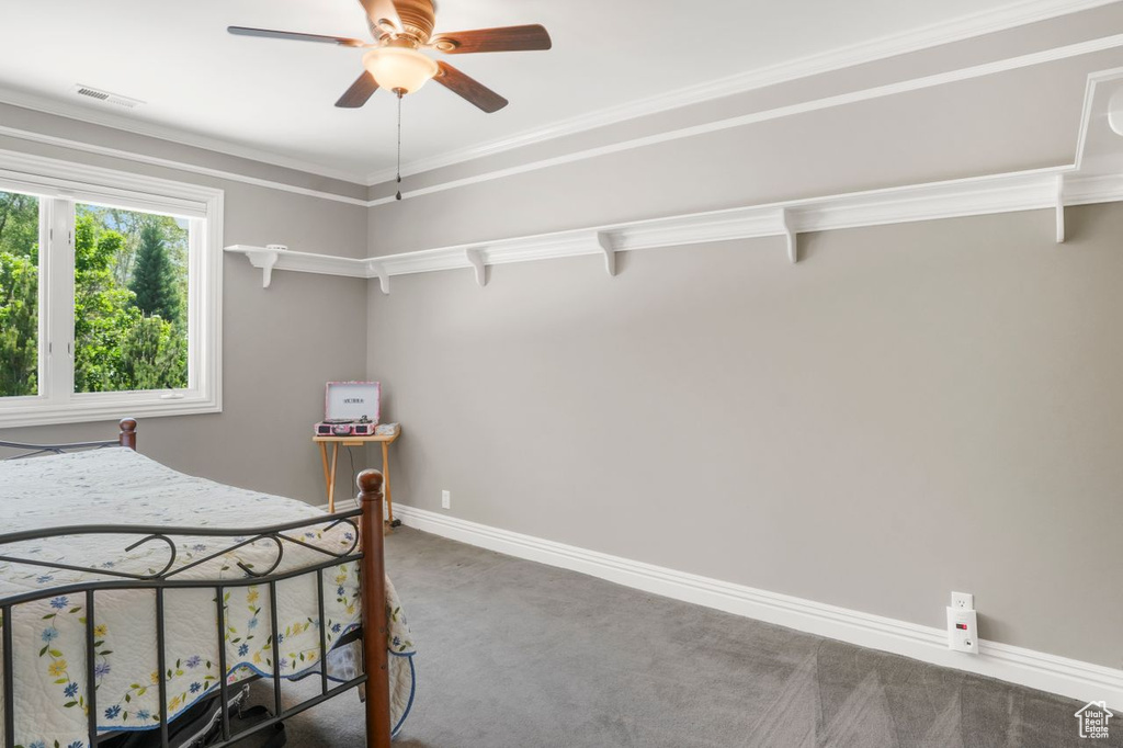 Carpeted bedroom featuring crown molding and ceiling fan