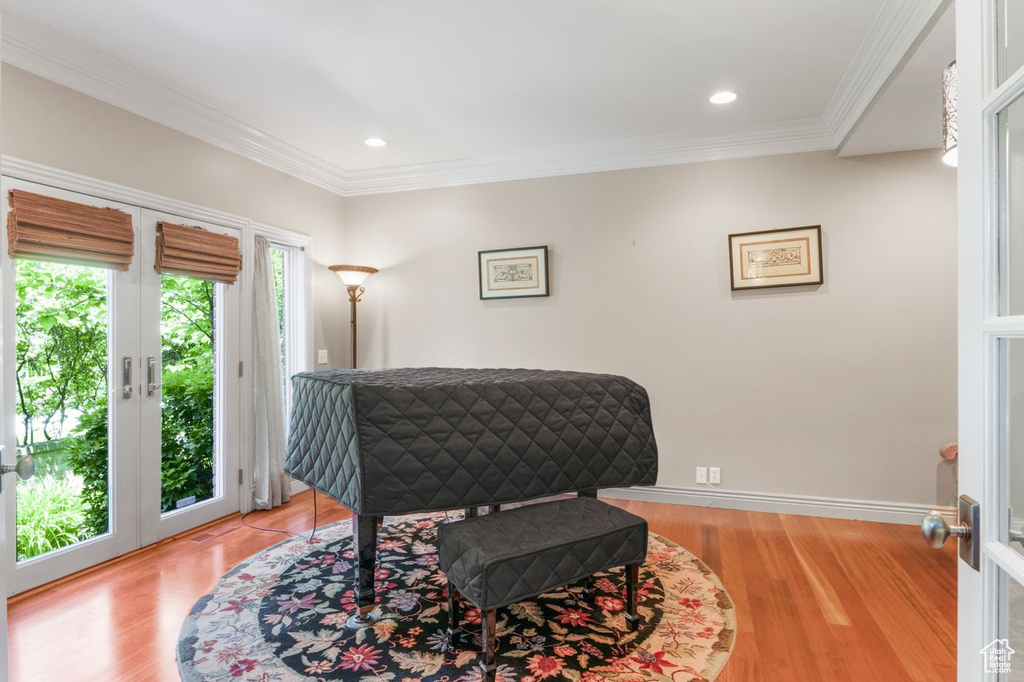 Living area featuring french doors, light hardwood / wood-style flooring, and ornamental molding