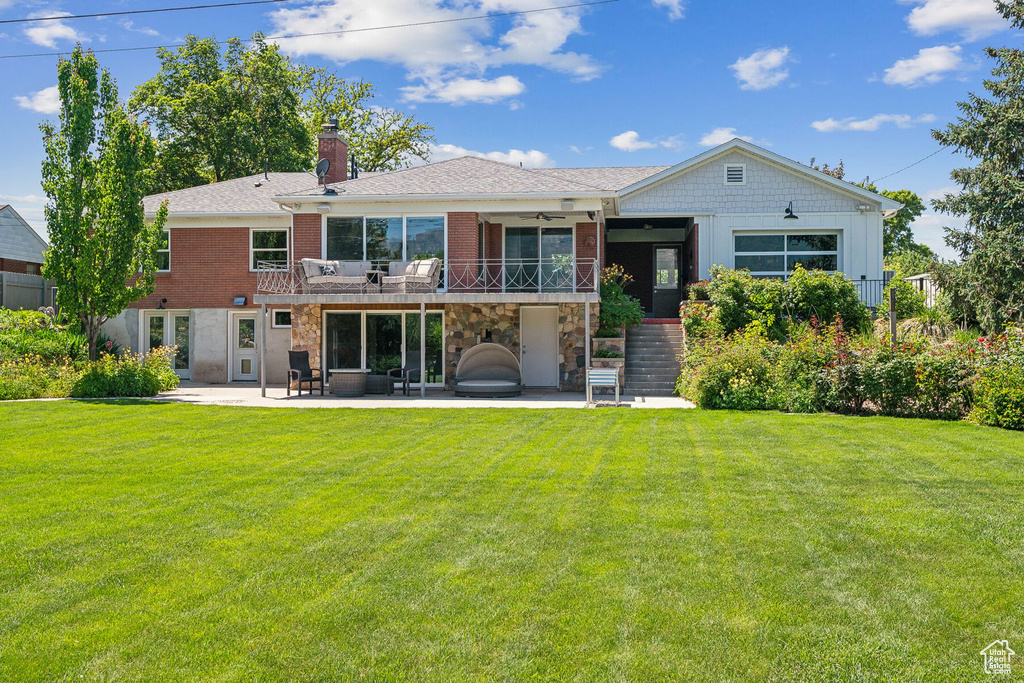 Rear view of property featuring a patio area, ceiling fan, stairs, a yard, and a chimney