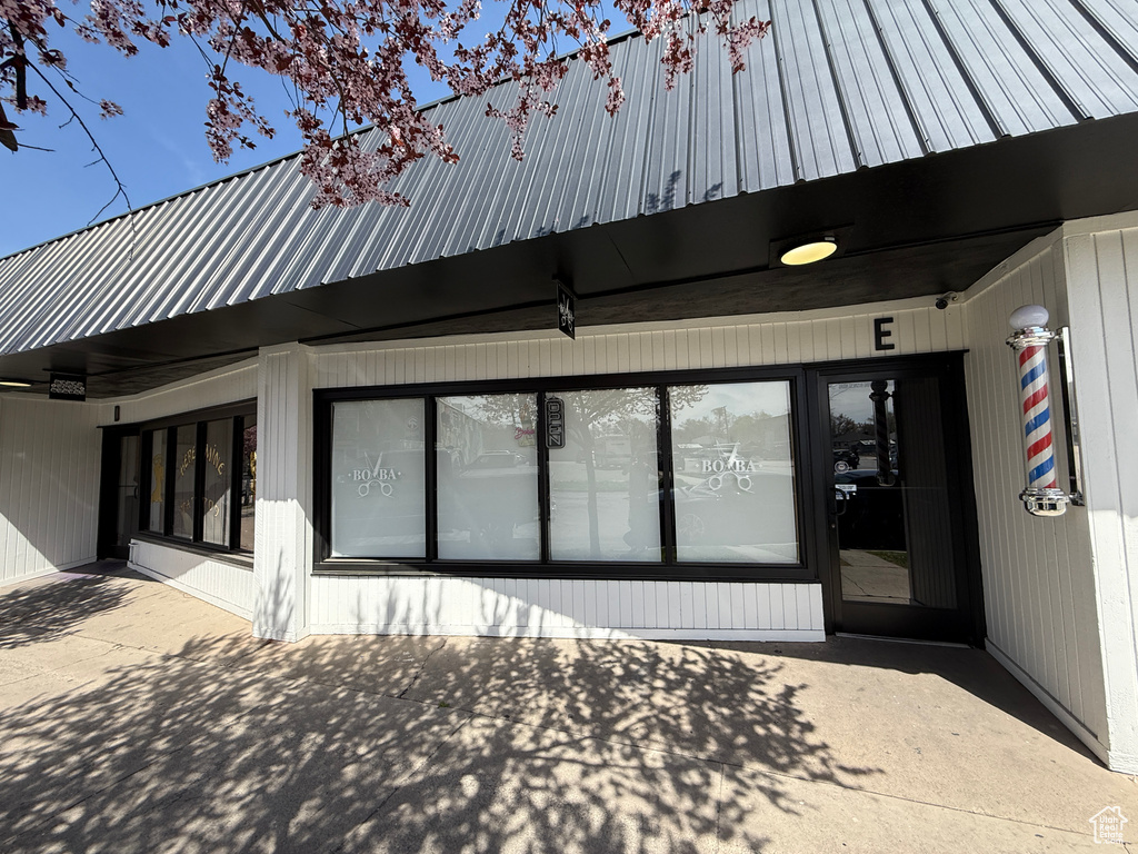 View of exterior entry with metal roof and a patio